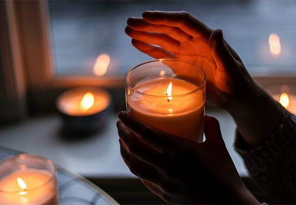 hand over candle glowing in the light